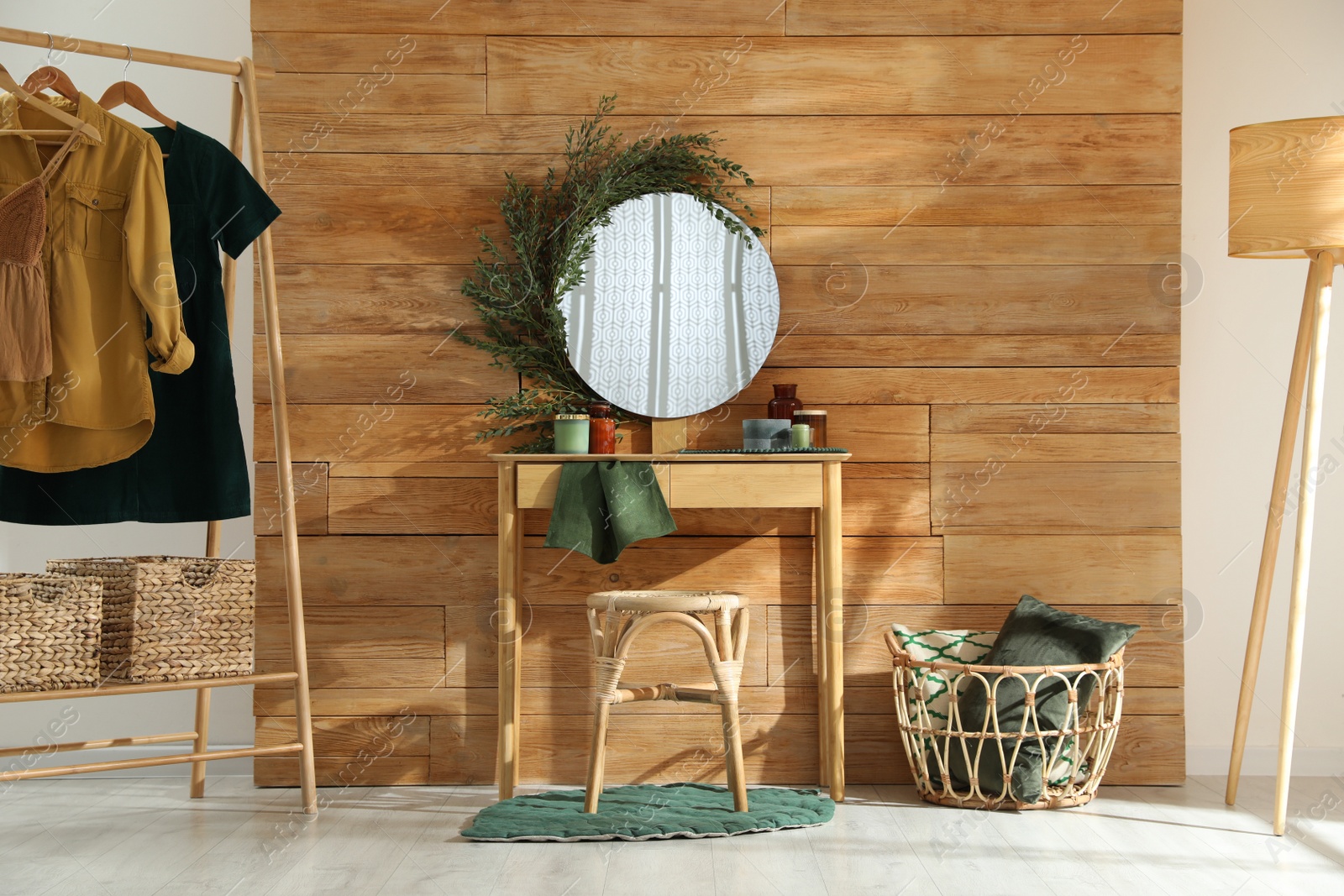 Photo of Stylish dressing table and mirror decorated with green eucalyptus in room