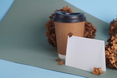 Photo of Dried hortensia flowers, blank card and paper cup on colorful background. Space for text