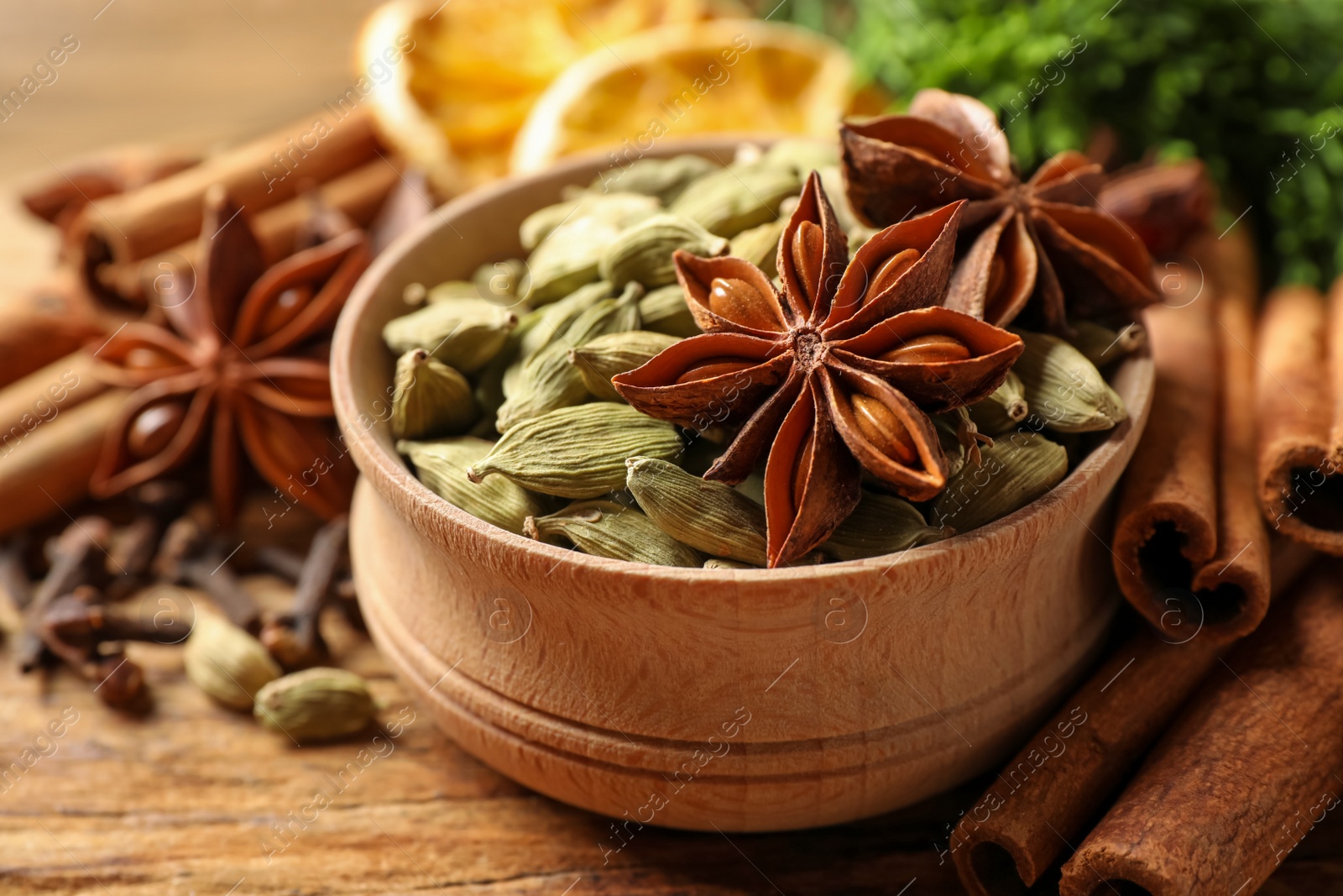 Photo of Dry anise stars, cardamon and cinnamon on wooden table, closeup. Mulled wine ingredients