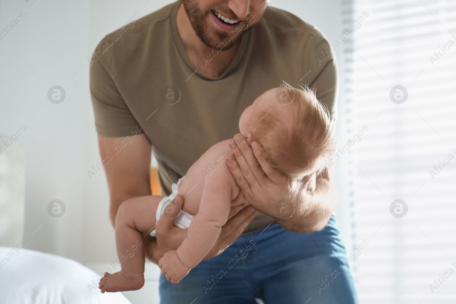 Photo of Father with his newborn son at home