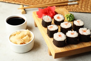 Photo of Tasty sushi rolls served on grey table