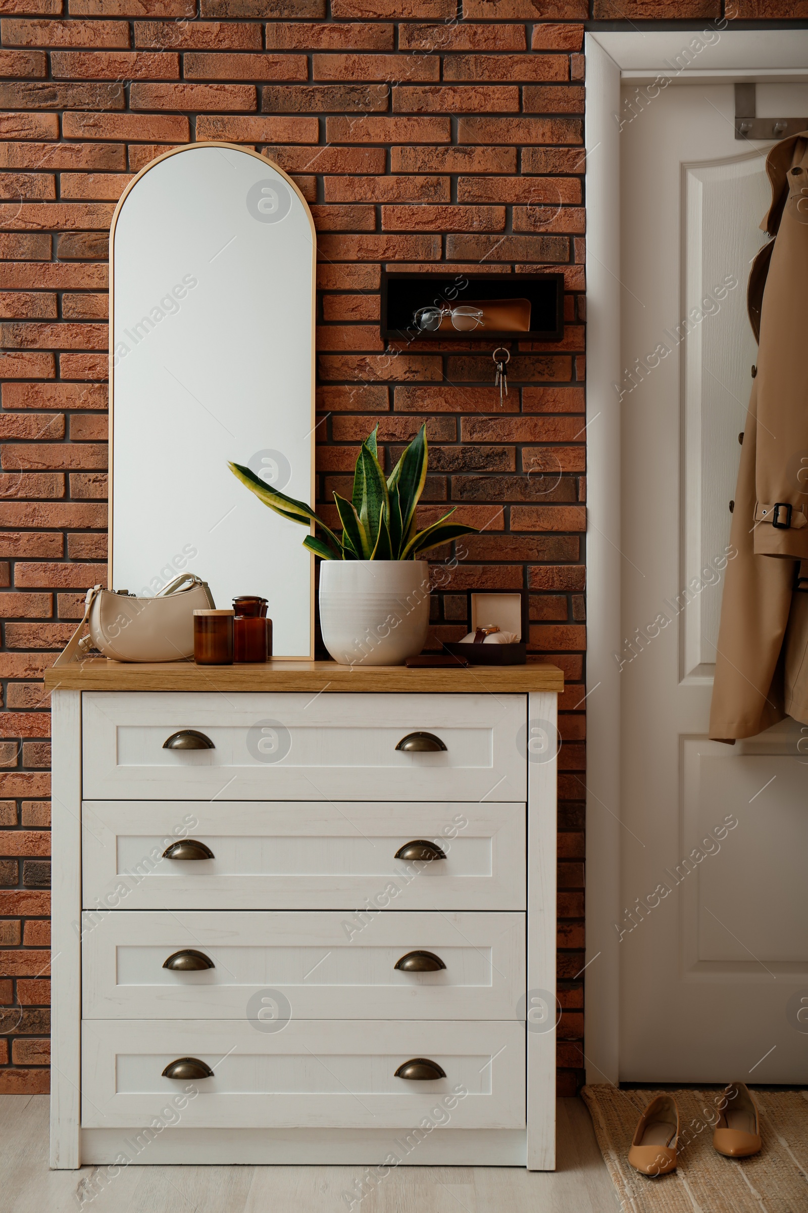 Photo of Stylish hanger for keys on brick wall in hallway