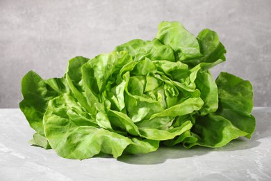 Photo of Fresh green butter lettuce on grey marble table