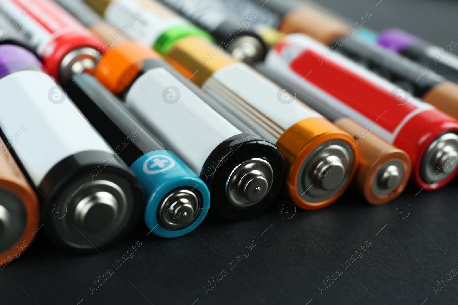 Image of Many different batteries on black background, closeup