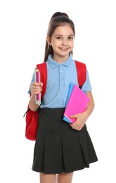 Cute little girl in school uniform with backpack and stationery on white background