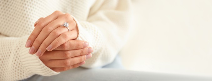 Image of Young woman wearing beautiful engagement ring, closeup view with space for text. Banner design