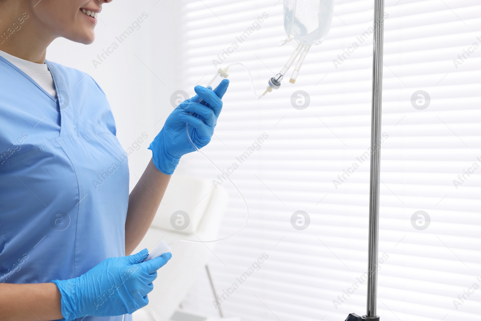 Photo of Nurse setting up IV drip in hospital, closeup