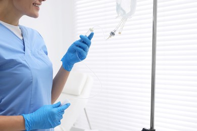 Nurse setting up IV drip in hospital, closeup