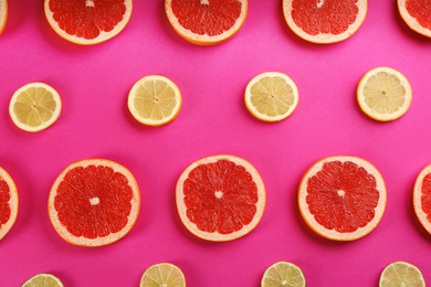 Photo of Flat lay composition with tasty ripe grapefruit slices on magenta background