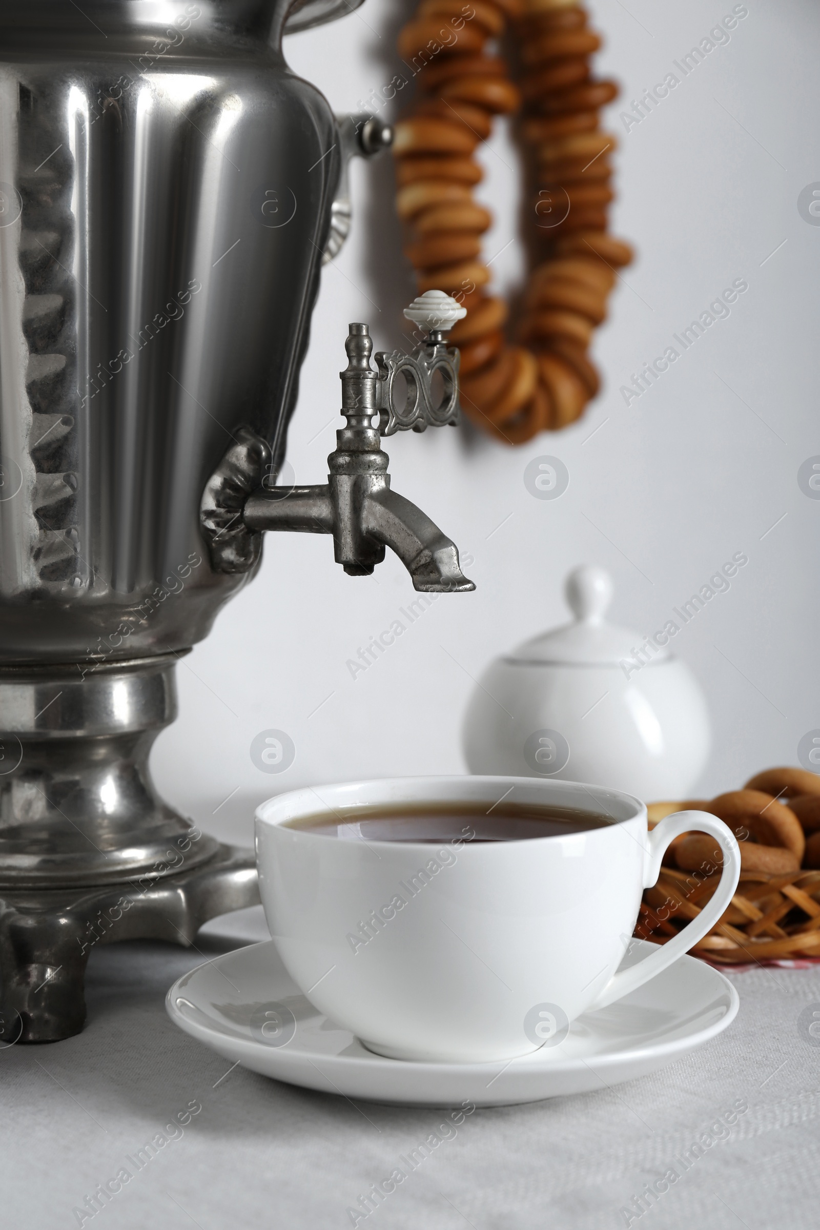 Photo of Composition with delicious ring shaped Sushki (dry bagels) and tea on white table