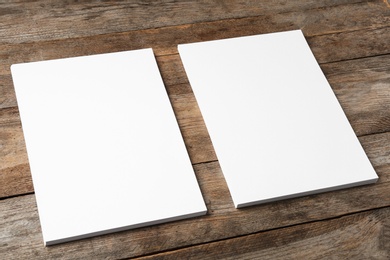 Photo of Blank paper sheets for brochure on wooden background. Mock up