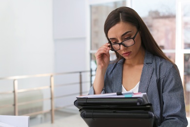 Photo of Young woman working with documents in office. Space for text