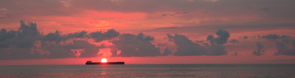 Beautiful sky with sun over sea at sunset, banner design. Ship sailing at sunset