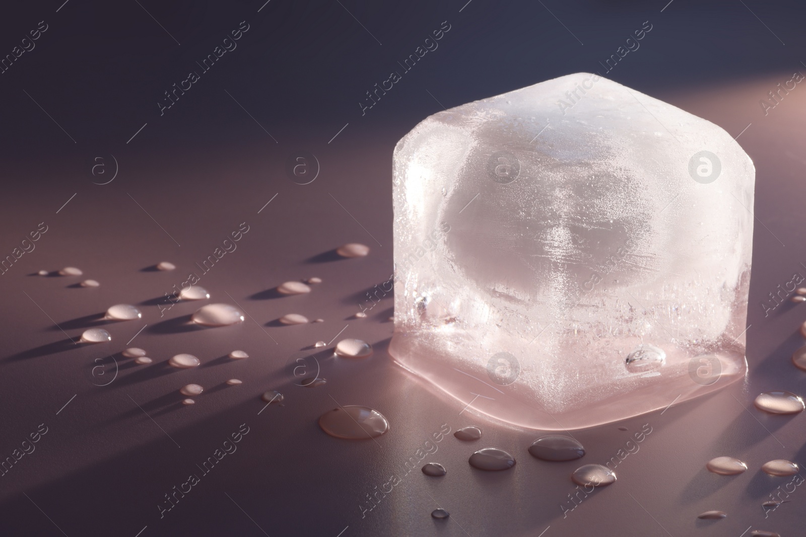 Photo of Crystal clear ice cube on pink background, closeup. Space for text