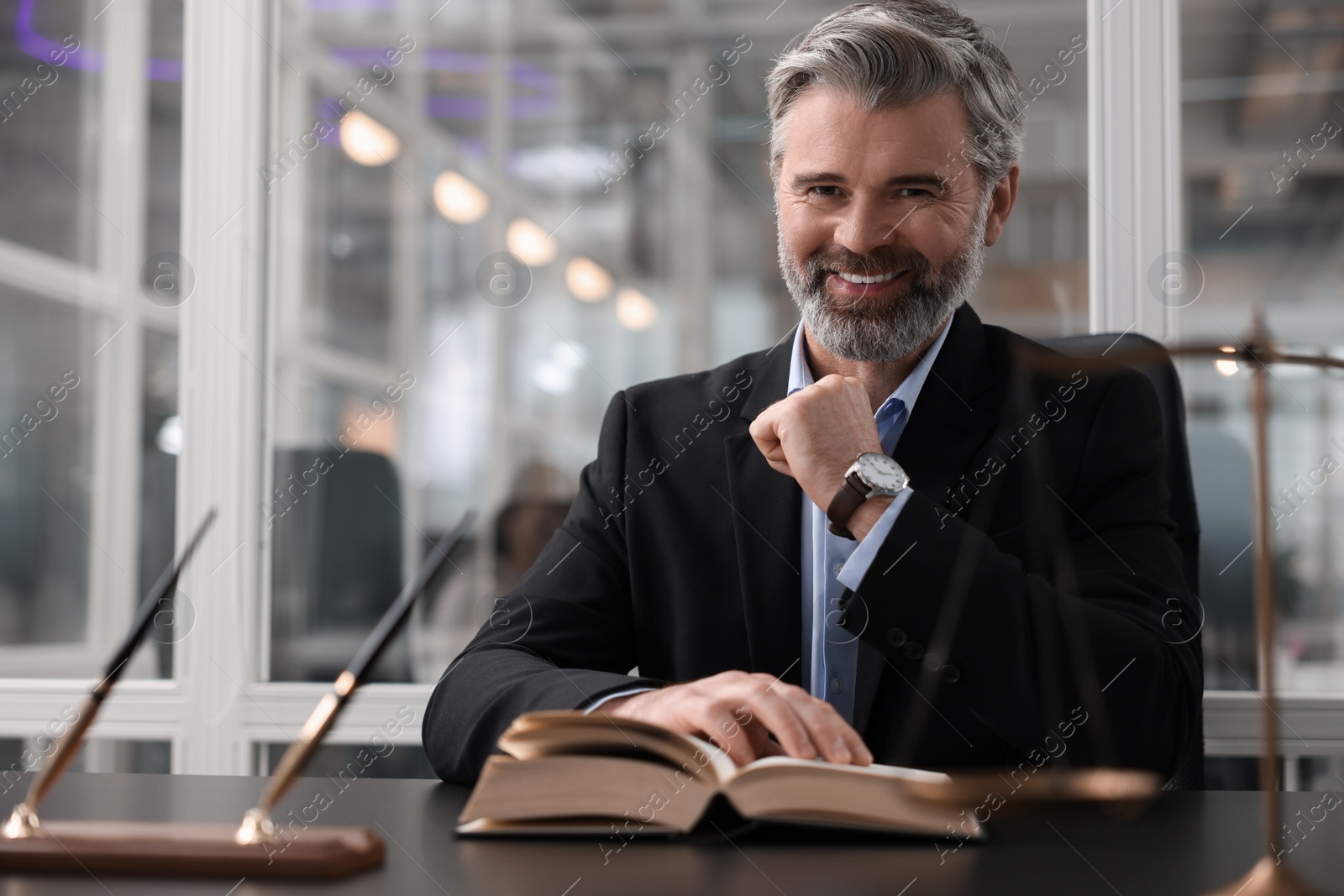 Photo of Portrait of smiling lawyer at table in office