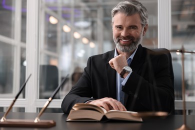 Portrait of smiling lawyer at table in office