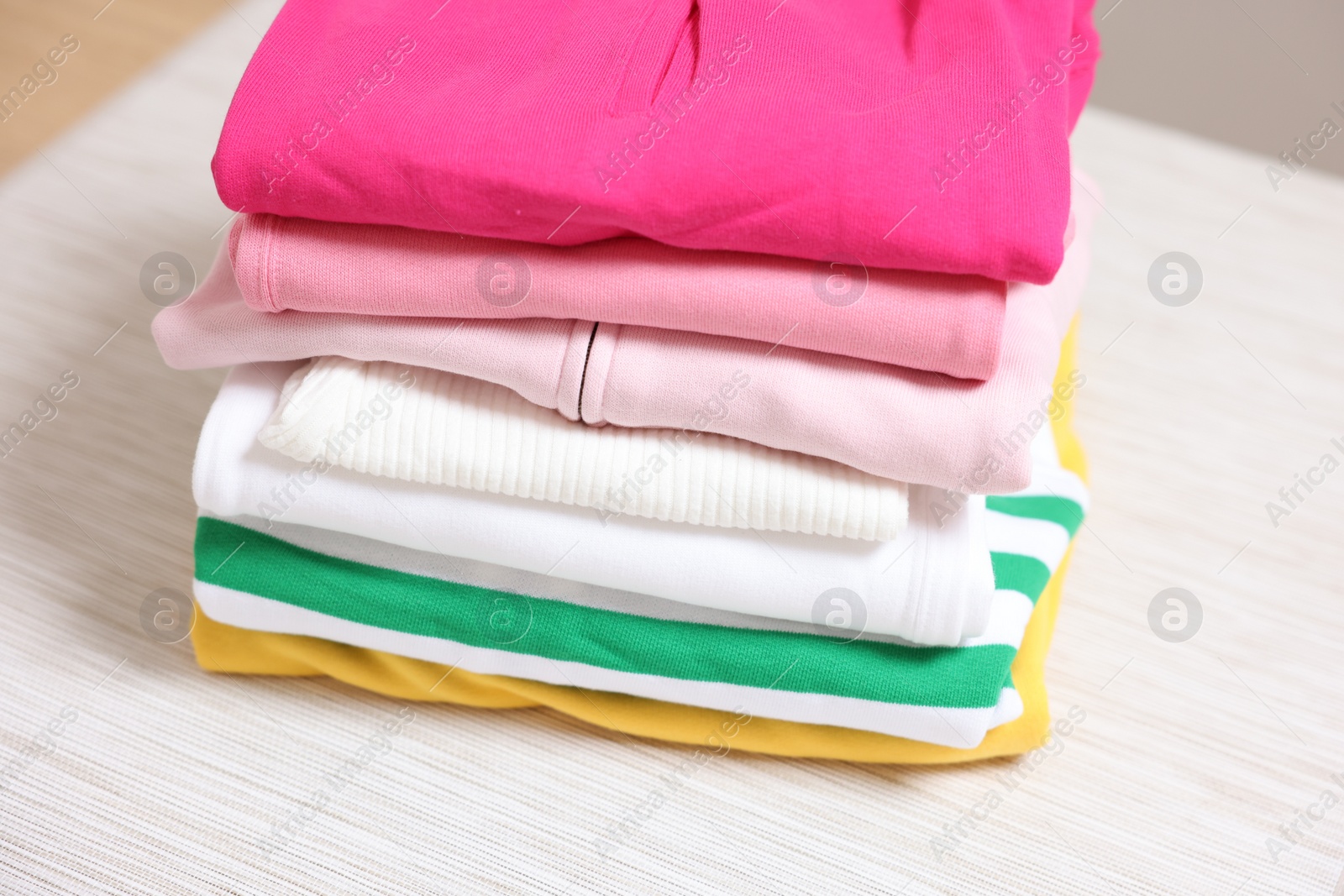 Stack of folded clothes on table, closeup Photo of Stack of folded clothes on table, closeup