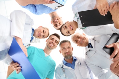 Photo of Group of doctors on light background, bottom view. Cardiology conference