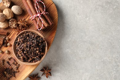 Photo of Different spices on light gray table, top view. Space for text