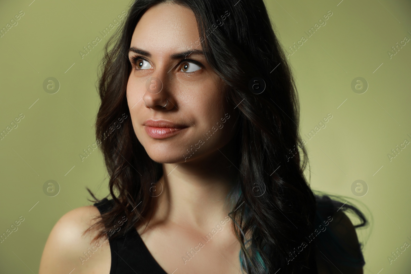 Photo of Beautiful young woman with nose piercing on green background