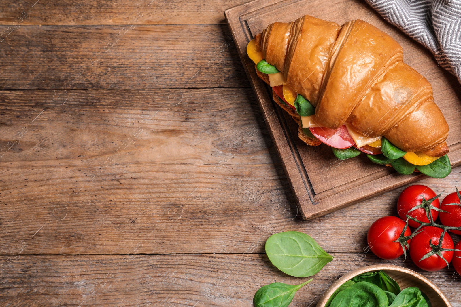 Photo of Flat lay composition with tasty croissant sandwich on wooden table. Space for text