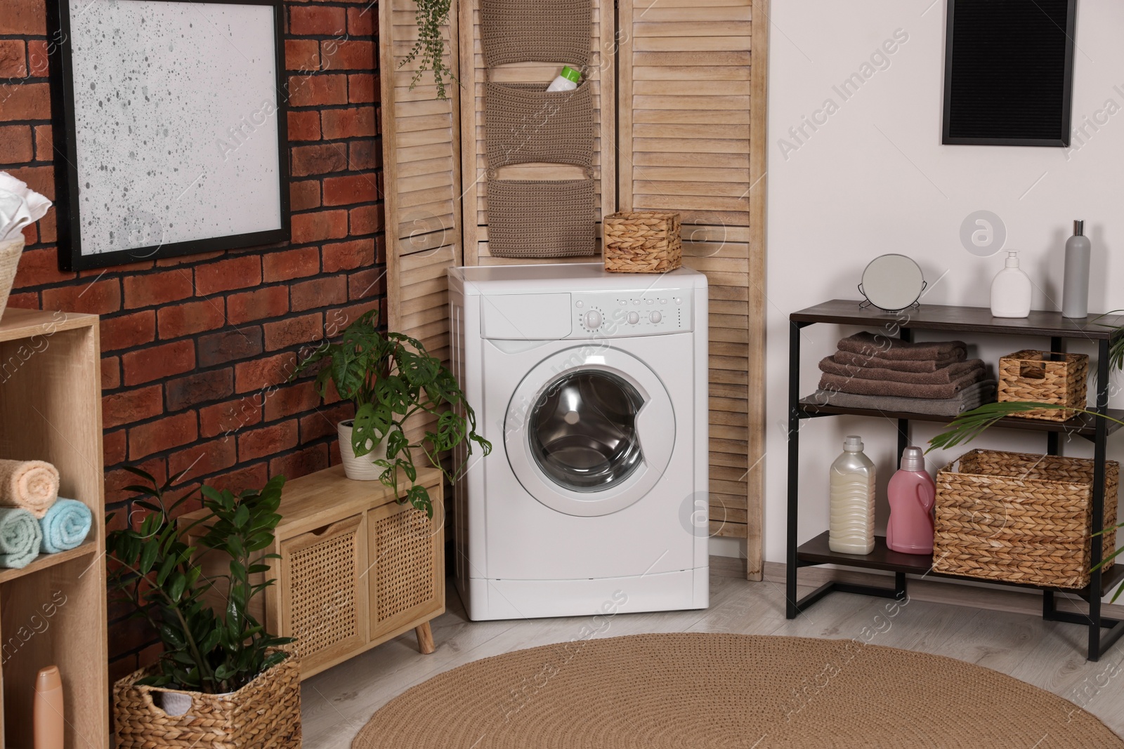 Photo of Stylish laundry room with washing machine. Interior design