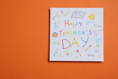 Photo of Paper with inscription HAPPY TEACHER'S DAY on orange background, top view. Space for text