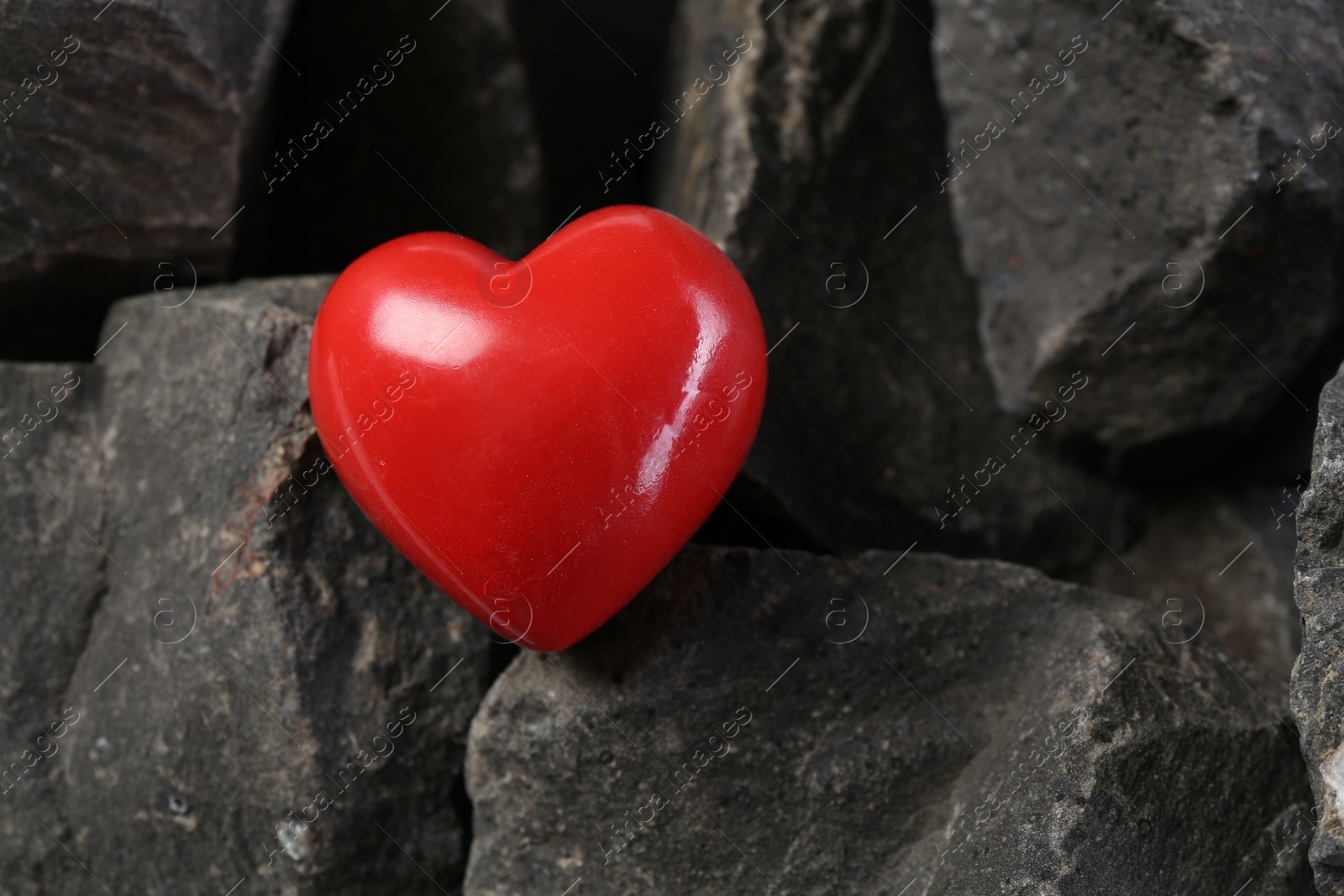 Photo of One red decorative heart on stones, above view