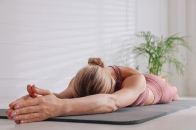 Photo of Woman practicing yoga on floor at home