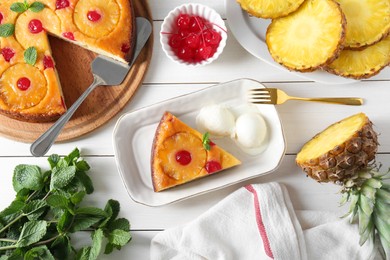 Photo of Delicious cut pineapple pie served with ice cream on white wooden table, flat lay