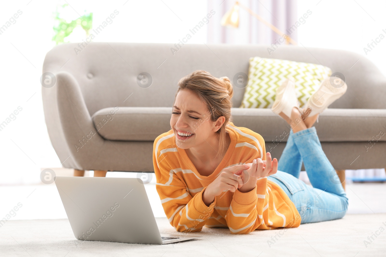 Photo of Woman using laptop for video chat in living room