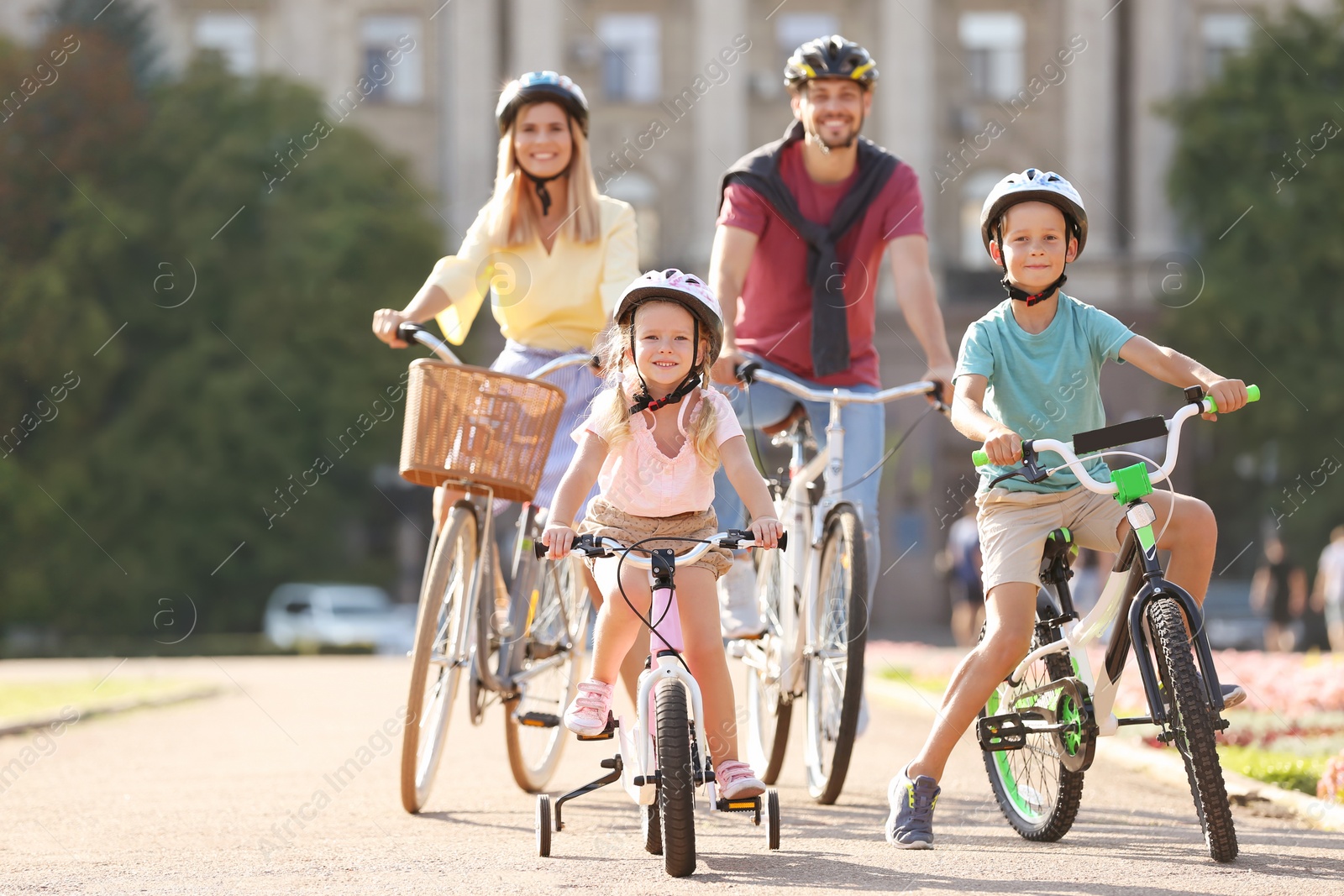 Photo of Happy family riding bicycles outdoors on summer day