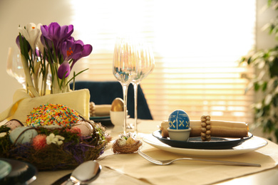 Festive Easter table setting with decorated eggs in kitchen