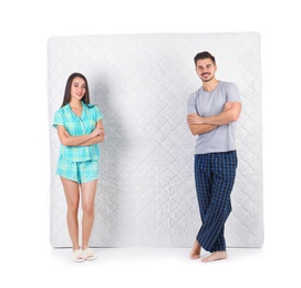 Young couple with comfortable mattress isolated on white