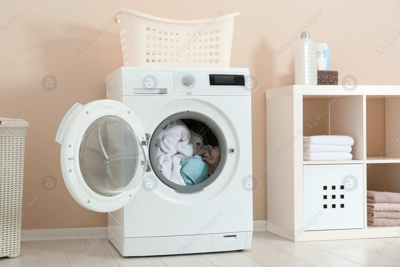 Photo of Crumpled towels in washing machine at home. Laundry room interior