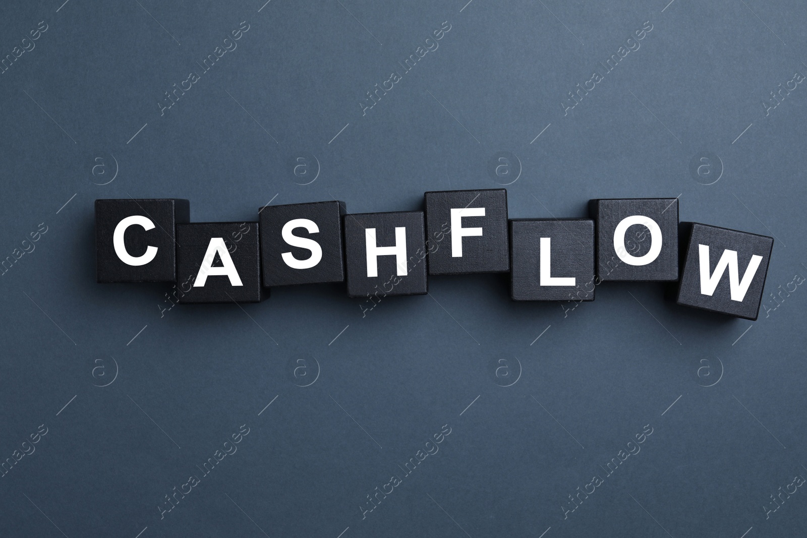 Image of Black wooden cubes with phrase Cash FLow on grey background, flat lay
