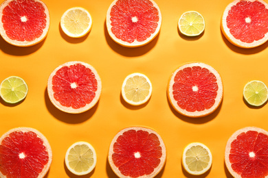 Flat lay composition with tasty ripe grapefruit slices on orange background