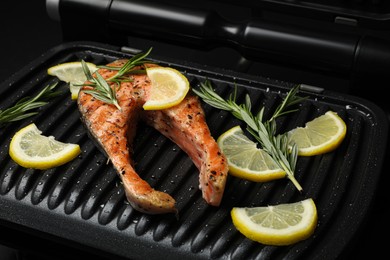 Photo of Cooking salmon. Grill with tasty fish steak, lemon and rosemary