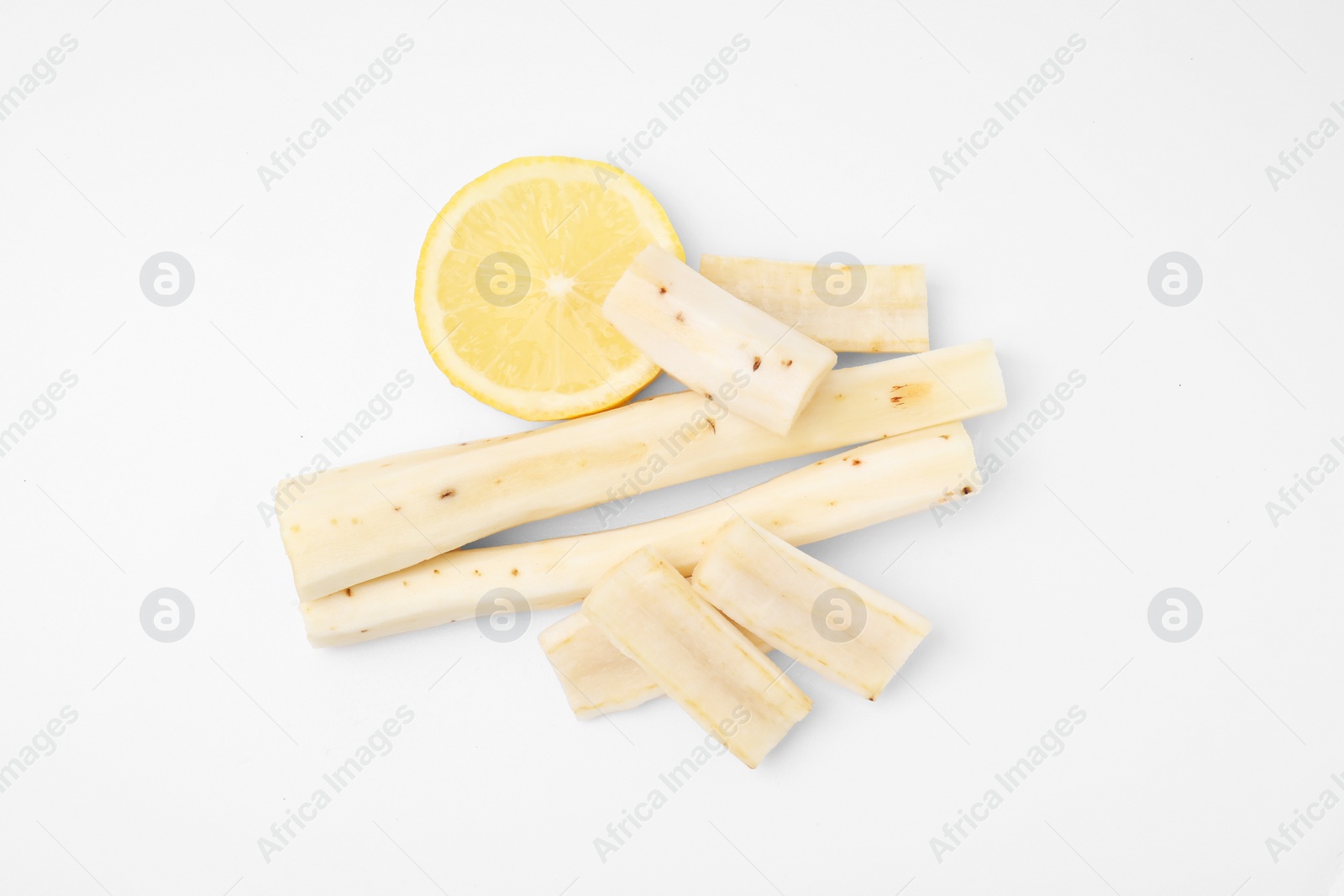 Photo of Cut raw salsify roots and lemon on white background, flat lay