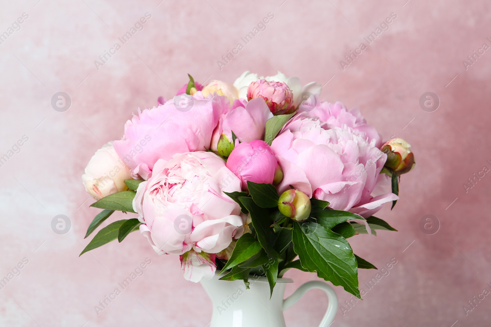 Photo of Bouquet of beautiful peonies in vase on pink background, closeup