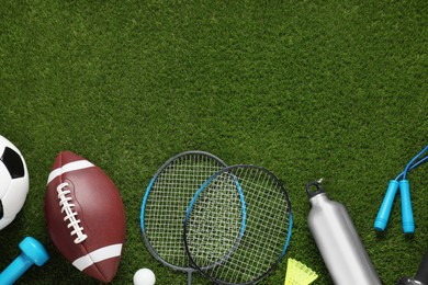 Photo of Different sport tools on green grass, flat lay. Space for text