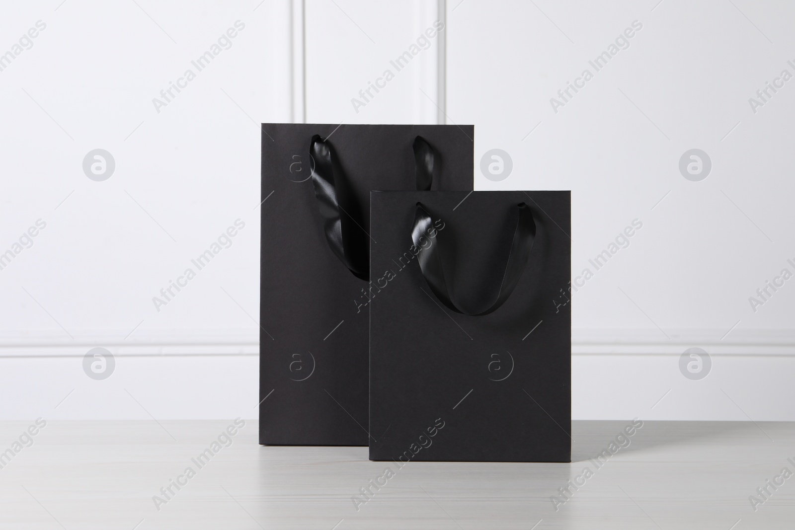 Photo of Black paper bag on white wooden table