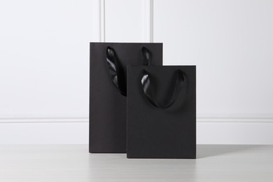 Black paper bag on white wooden table