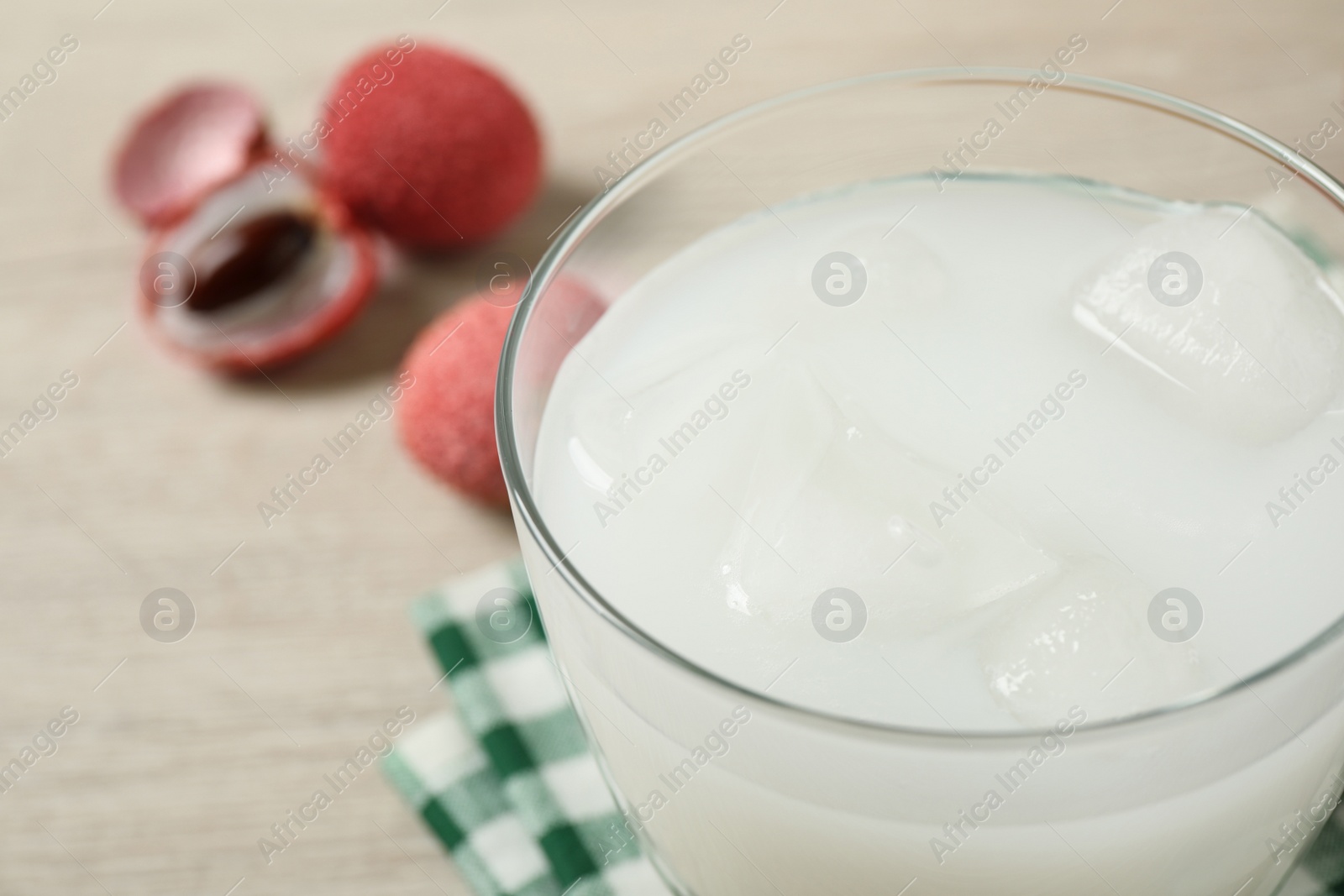 Photo of Glass with fresh lychee juice on table, closeup