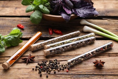 Photo of Composition with fragrant spices in glass test tubes on wooden table