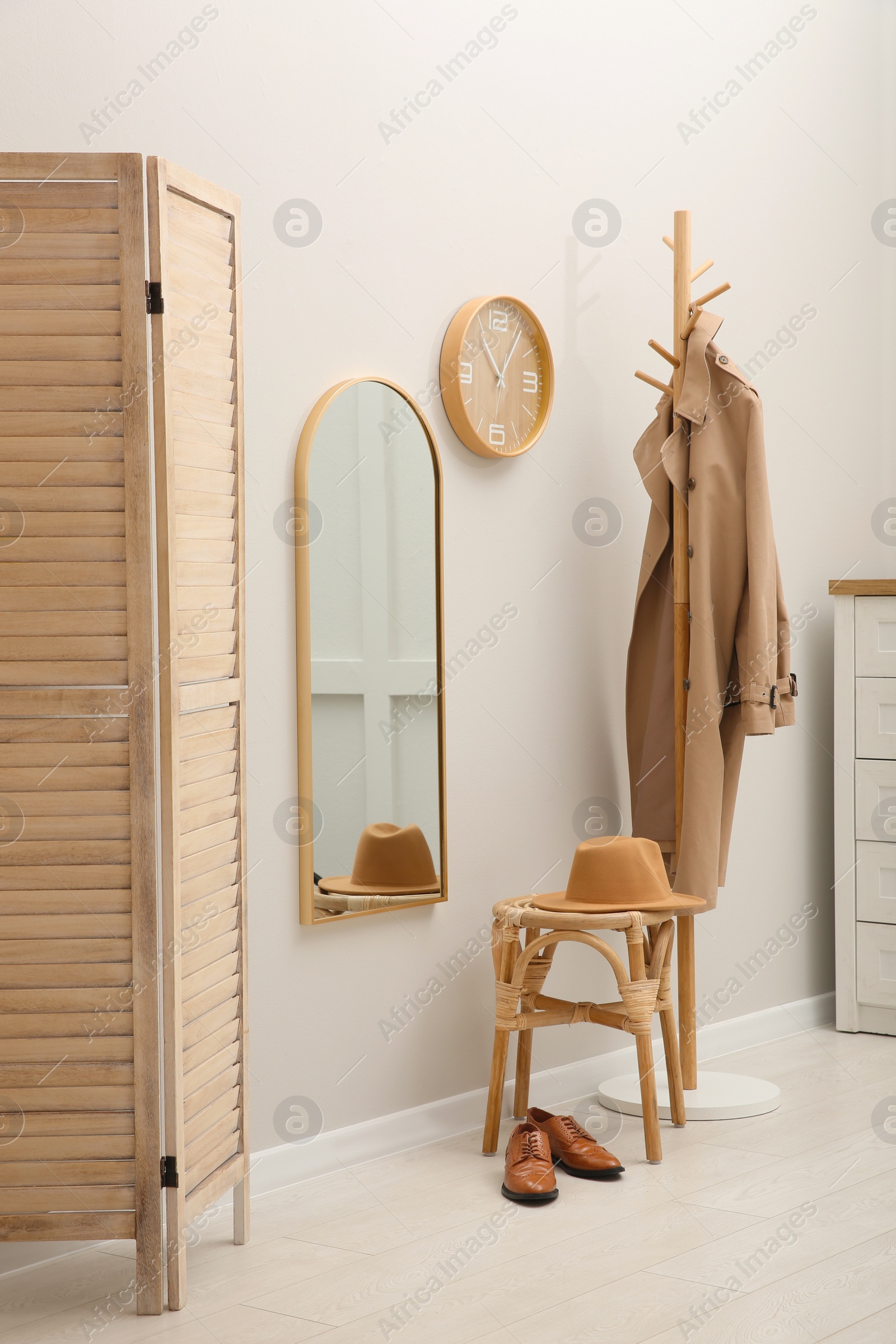 Photo of Hallway interior with wooden furniture near light wall. Stylish accessories