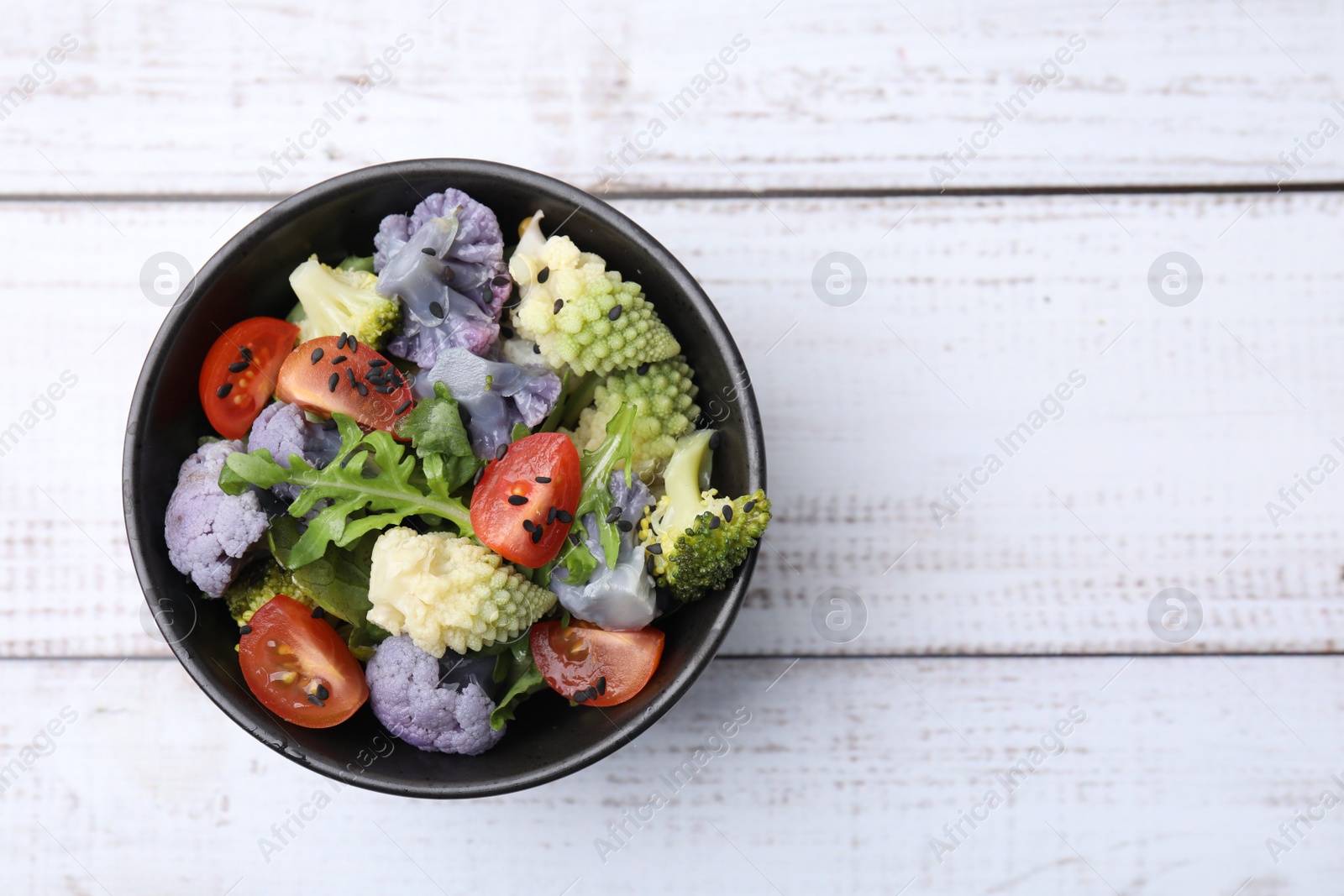 Photo of Delicious salad with cauliflower and tomato on white wooden table, top view. Space for text