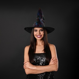 Beautiful woman wearing witch costume for Halloween party on black background