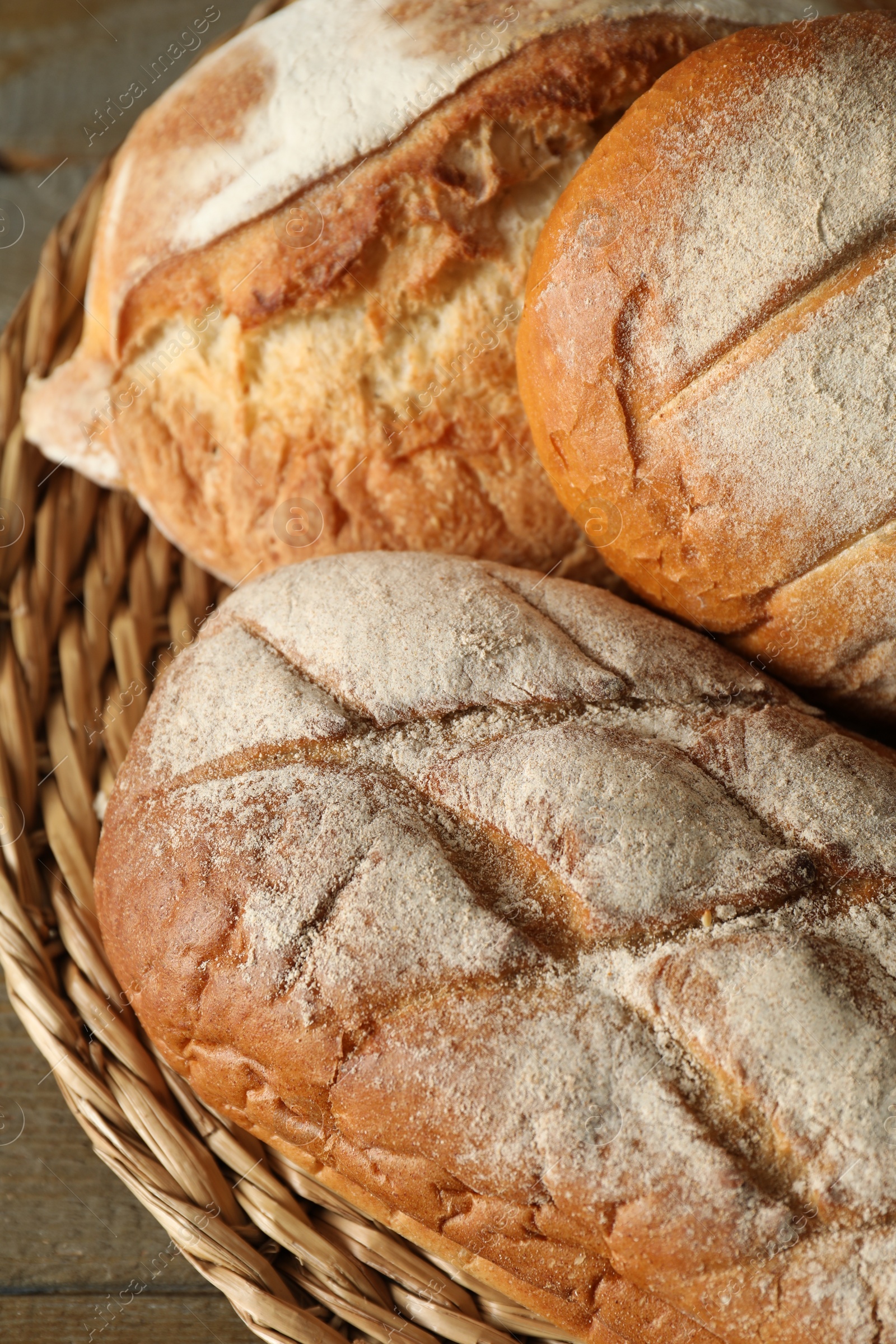 Photo of Basket with different types of fresh bread on table, closeup