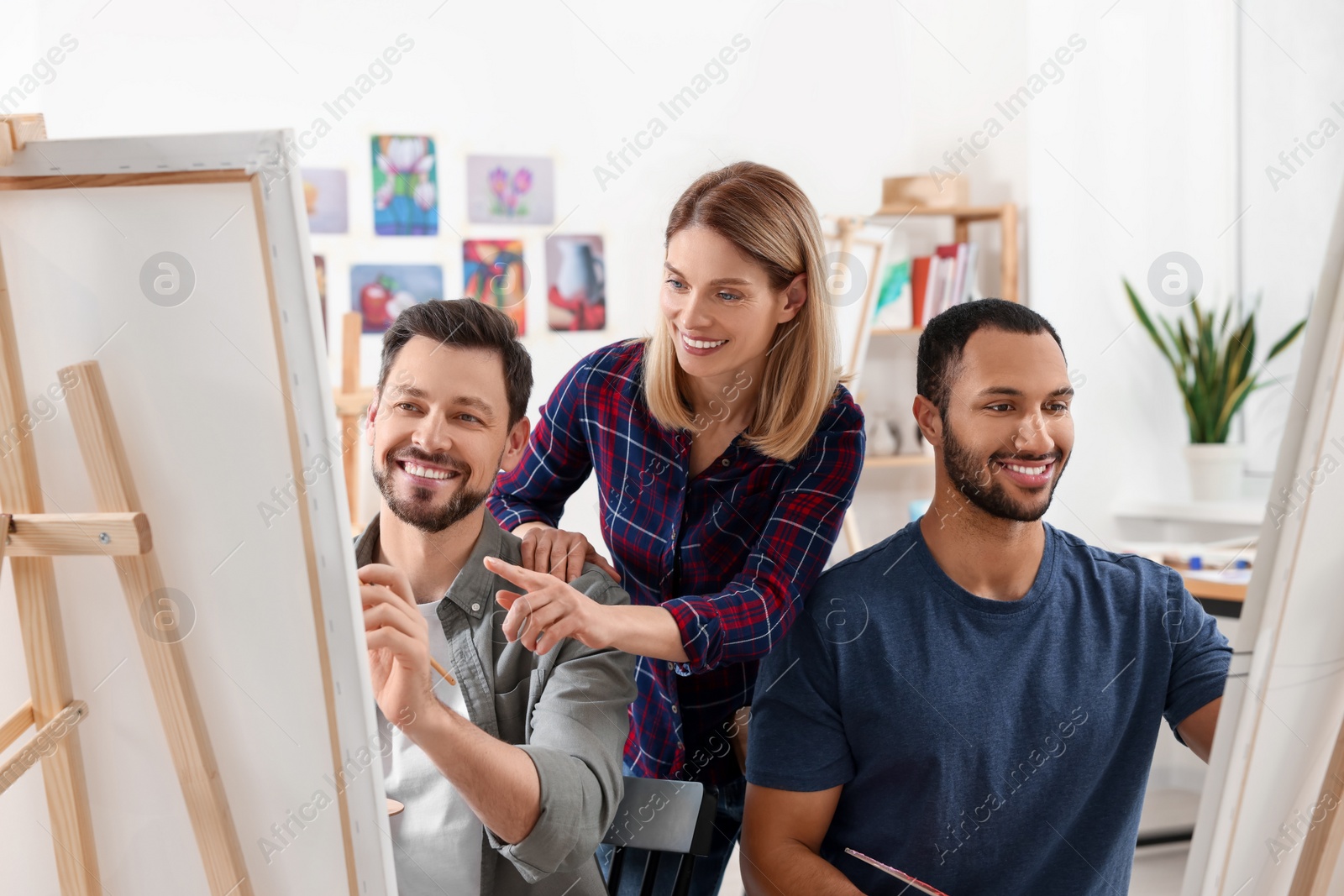 Photo of Artist teaching her students to paint in studio. Creative hobby